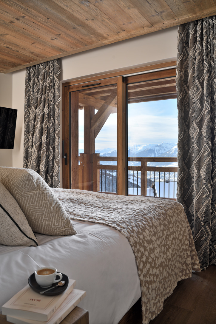 Chambre du 2e étage d'Epicime Lodge : lit ouvert sur la terrasse couverte et les sommets enneigés de Peisey-Vallandry