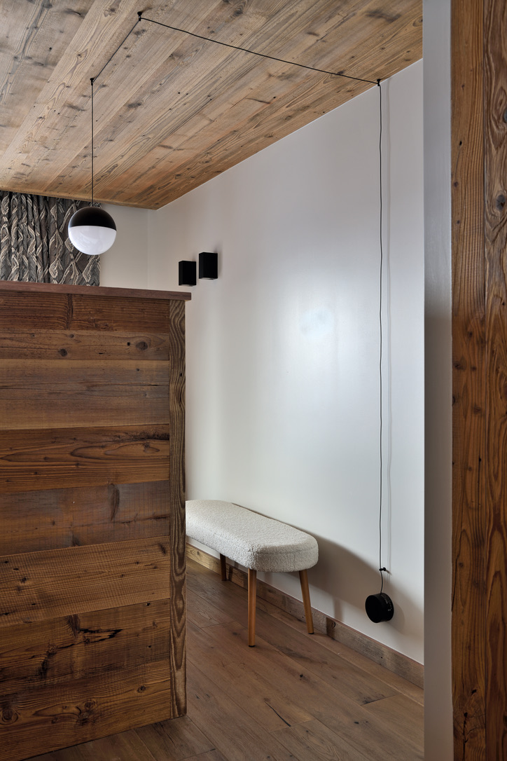 Banc bouclé et boiseries anciennes dans une chambre du 2e étage d'Epicime Lodge