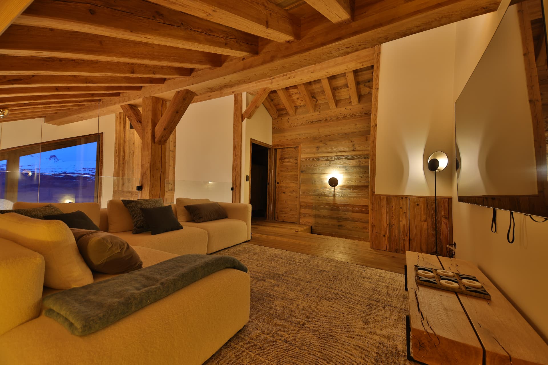 Espace détente avec écran mural à la lumière du soir, au 4e étage d'Epicime Lodge