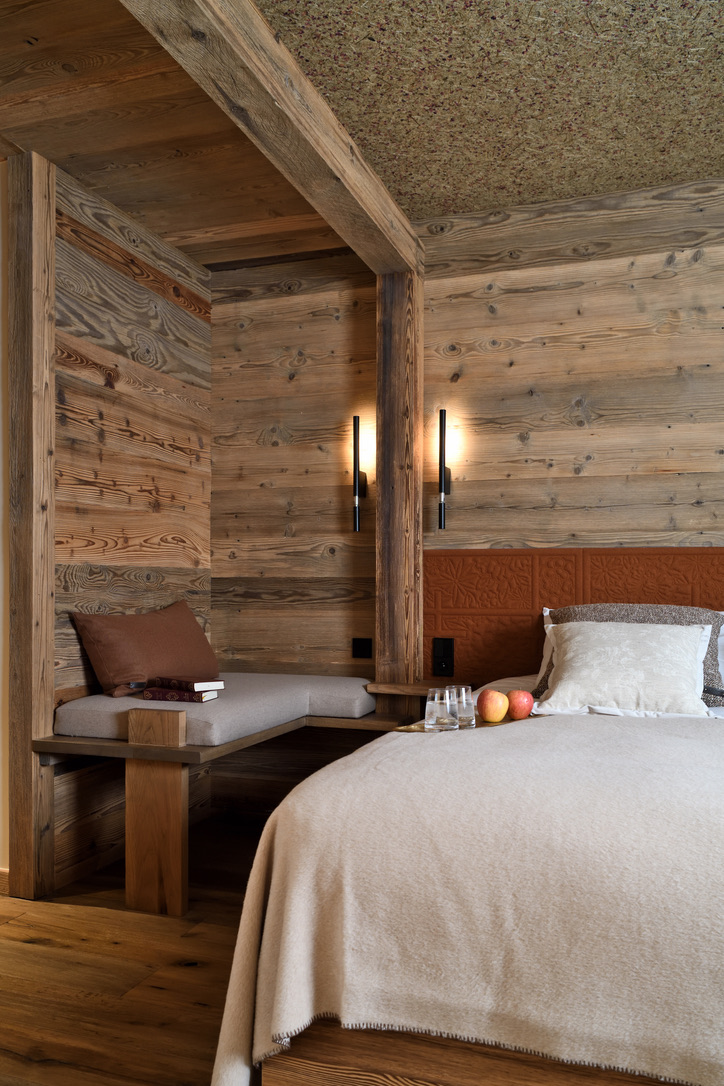 Coin banquette d'une chambre du 1er étage, bois brut et laine, ambiance feutrée