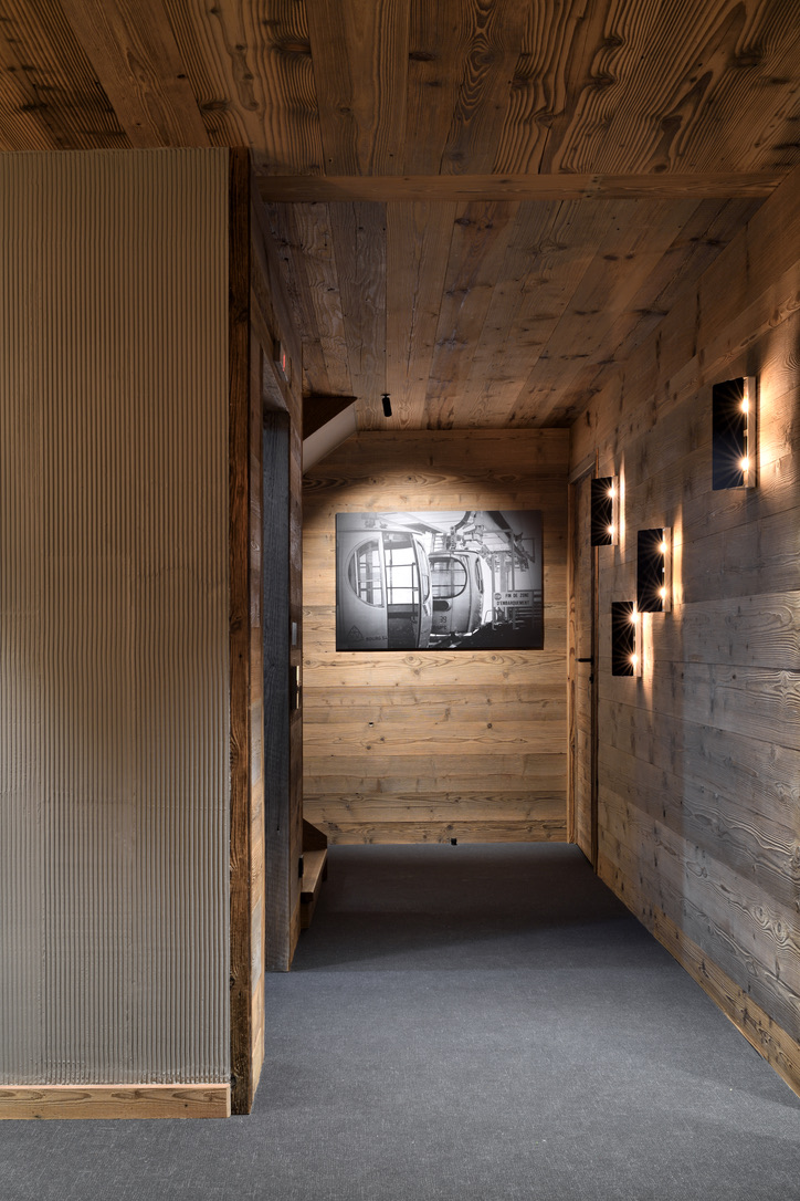 Couloir du rez-de-chaussée en bois ancien, photographie de télécabine et appliques contemporaines