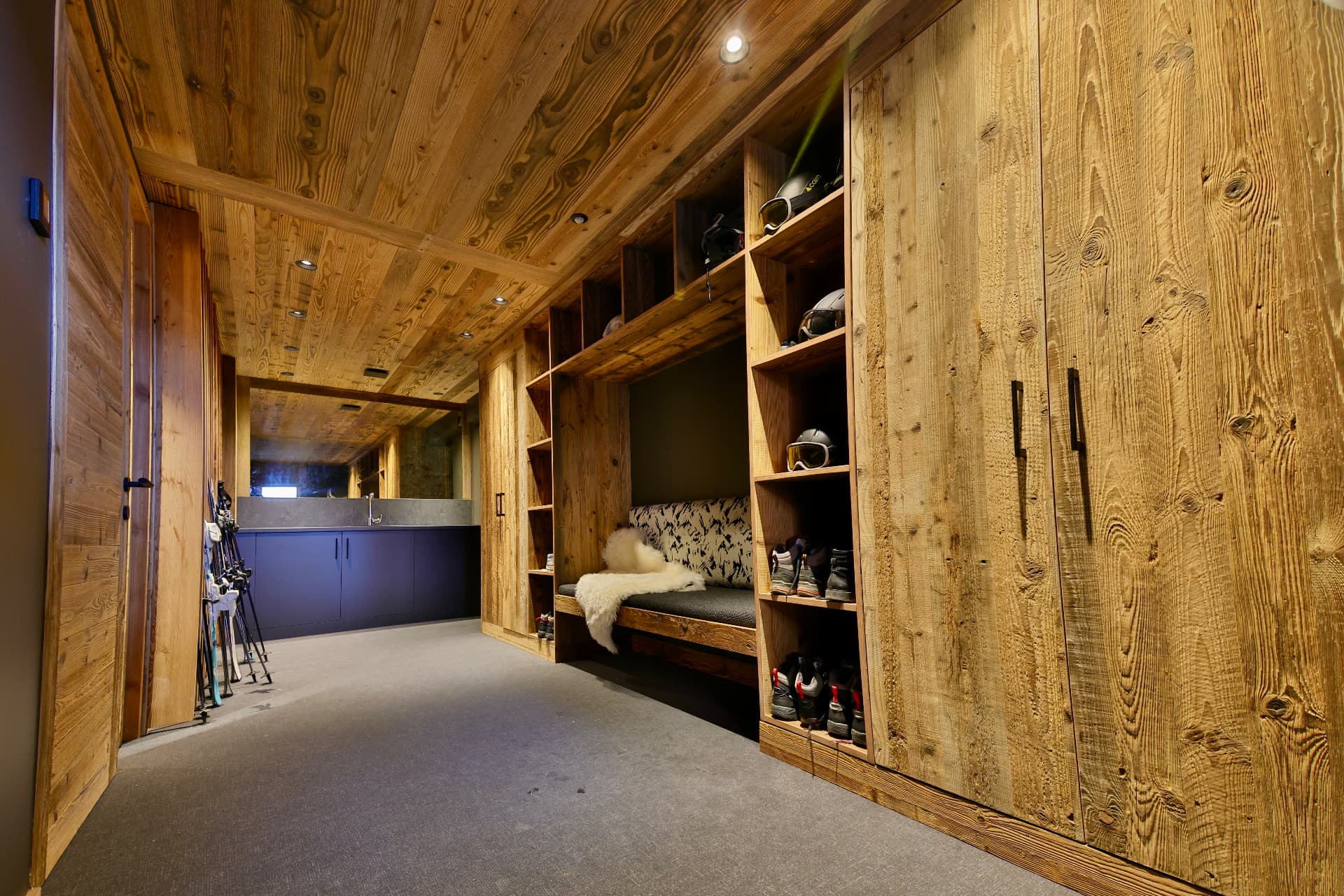 Ski-room en bois d’Epicime Lodge avec rangements pour le matériel et banc pour se préparer