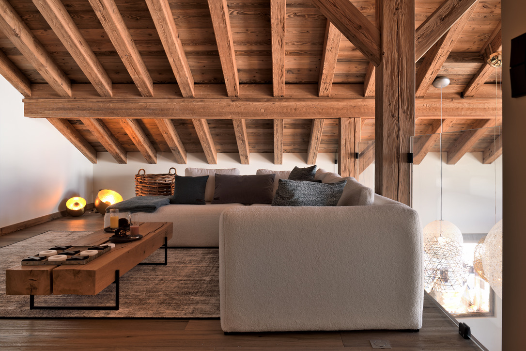 Coin salon feutré sous la charpente, au sommet d'Epicime Lodge